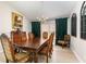 Elegant dining room featuring an ornate table set, hardwood floors, and a window with dark drapes at 2735 Lido Key Dr, Kissimmee, FL 34747