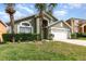 Charming home with a well-manicured lawn, palm trees, and a two-car garage at 2735 Lido Key Dr, Kissimmee, FL 34747