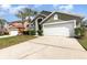 Charming home featuring a two-car garage, manicured lawn, and mature palm trees at 2735 Lido Key Dr, Kissimmee, FL 34747
