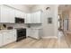 Bright kitchen with white cabinets, stainless steel appliances, and wood look flooring at 2735 Lido Key Dr, Kissimmee, FL 34747