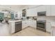 Modern kitchen featuring stainless steel appliances, white cabinetry, and a view of the living area at 2735 Lido Key Dr, Kissimmee, FL 34747