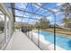 Spacious screened-in pool area with a safety fence, comfortable seating, and views of the backyard at 2735 Lido Key Dr, Kissimmee, FL 34747