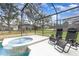 Relaxing screened-in pool area with lounge chairs and a soothing hot tub for leisure at 2735 Lido Key Dr, Kissimmee, FL 34747