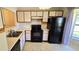 Efficient kitchen featuring white cabinets, a black refrigerator, and ample counter space at 2781 King Oak Cir, St Cloud, FL 34769