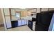 Functional kitchen with white cabinets, black appliances, and a view to the living area at 2781 King Oak Cir, St Cloud, FL 34769