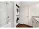 Bathroom features shower over tub, stackable washer/dryer, and white tile at 2903 Edenshire Way # 103, Kissimmee, FL 34746