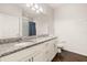 Well-lit bathroom with double sink vanity, granite countertop, and a framed mirror at 2903 Edenshire Way # 103, Kissimmee, FL 34746