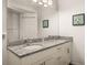 Bathroom with double granite vanity, stylish mirrors, and ample cabinet space at 2903 Edenshire Way # 103, Kissimmee, FL 34746