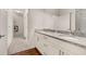 Bathroom features double vanity with granite countertop, wood floors, and white cabinets at 2903 Edenshire Way # 103, Kissimmee, FL 34746