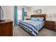 Bedroom featuring a bed with blue and white striped bedding, matching end tables, and blue curtains at 2903 Edenshire Way # 103, Kissimmee, FL 34746