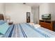Inviting bedroom with blue and white striped bedding, a television and framed wall art at 2903 Edenshire Way # 103, Kissimmee, FL 34746