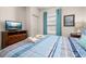 Comfortable bedroom with a television, bedside table and lamp, and a view through the window at 2903 Edenshire Way # 103, Kissimmee, FL 34746