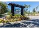 Community entrance sign with mature landscaping and colorful flowers at 2903 Edenshire Way # 103, Kissimmee, FL 34746