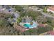Aerial view of community pool with lounge seating and swaying palm trees at 2903 Edenshire Way # 103, Kissimmee, FL 34746