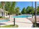 Community pool area with lounge seating, jacuzzi, and swaying palm trees at 2903 Edenshire Way # 103, Kissimmee, FL 34746