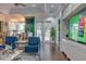 Lobby area with comfortable seating, TV, and an accent wall with faux plants at 2903 Edenshire Way # 103, Kissimmee, FL 34746