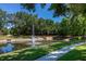 Scenic pond with a fountain surrounded by lush greenery and trees in the community at 2903 Edenshire Way # 103, Kissimmee, FL 34746