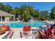 Community pool with lounge chairs, blue water, trees, and a water feature at 2903 Edenshire Way # 103, Kissimmee, FL 34746