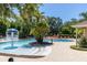 Community pool with water feature, lounge chairs, landscaping and shade trees at 2903 Edenshire Way # 103, Kissimmee, FL 34746