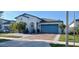 Inviting single-story home with a blue garage door, brick driveway, and tropical landscaping at 2950 Scarlett Dr, St Cloud, FL 34772