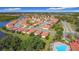 Community aerial view featuring a swimming pool, lakes, and numerous homes with terra cotta roofs at 3105 Sangria St, Kissimmee, FL 34744