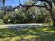Community basketball court framed by mature trees and mossy branches on a sunny day at 3105 Sangria St, Kissimmee, FL 34744