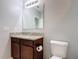 Bathroom with granite vanity top, cabinet storage and a decorative mirror with vanity lights at 3105 Sangria St, Kissimmee, FL 34744