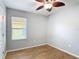 This bedroom features wood-look tile flooring and a window with blinds at 3105 Sangria St, Kissimmee, FL 34744