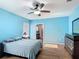 Light blue bedroom features a ceiling fan and wood look flooring that leads into the ensuite bathroom at 3105 Sangria St, Kissimmee, FL 34744