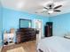 Spacious light blue bedroom with wood look flooring includes a bedroom set and view into another room at 3105 Sangria St, Kissimmee, FL 34744