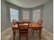 Cozy dining room with wood table, four chairs and natural light coming from three windows at 3105 Sangria St, Kissimmee, FL 34744