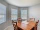 Cozy dining room with wood table, four chairs and natural light coming from three windows at 3105 Sangria St, Kissimmee, FL 34744