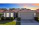 Charming single-story home featuring a red tile roof, neutral stucco, two-car garage, and manicured landscaping at 3105 Sangria St, Kissimmee, FL 34744