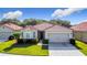 Charming home features a tile roof, attached two-car garage, and beautifully landscaped front yard at 3105 Sangria St, Kissimmee, FL 34744