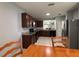 Traditional kitchen features dark cabinetry, stainless steel refrigerator, granite countertops, and tile flooring at 3105 Sangria St, Kissimmee, FL 34744