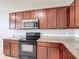 Well-equipped kitchen with dark cabinets, granite countertops, and stainless steel microwave at 3105 Sangria St, Kissimmee, FL 34744