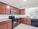 Kitchen with dark cabinets, granite countertops, black appliances, and view into the living room at 3105 Sangria St, Kissimmee, FL 34744