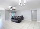 Open living space with tile floors, a ceiling fan, barn doors, and a comfortable leather sofa at 3105 Sangria St, Kissimmee, FL 34744