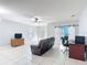 Large living room with ceiling fan, tile floors, barn doors, and a comfortable leather sofa at 3105 Sangria St, Kissimmee, FL 34744