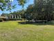 Community playground with play structure, gazebo, mature trees, and green grass under a blue sky at 3105 Sangria St, Kissimmee, FL 34744