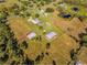 Stunning aerial view showcasing the property's expansive acreage, featuring a main house, outbuildings, and picturesque surroundings at 3255 Tucker Ave, St Cloud, FL 34772