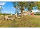 Inviting two-story home with a charming front porch and a detached garage, surrounded by lush landscaping and shade trees at 3255 Tucker Ave, St Cloud, FL 34772