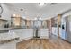 Bright kitchen boasts granite counters, white cabinetry, stainless steel appliances, and wood-look flooring at 3255 Tucker Ave, St Cloud, FL 34772