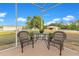 Cozy patio setting with wicker chairs, a table with flowers, and peaceful views of the property at 3255 Tucker Ave, St Cloud, FL 34772