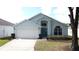 Charming one-story home features a two-car garage, manicured lawn, and beautiful windows at 334 Grosvenor Loop, Davenport, FL 33897