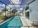 Relaxing pool featuring a screened enclosure and access to the home's interior and views to other screened pools at 334 Grosvenor Loop, Davenport, FL 33897