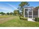 Expansive backyard view overlooking the golf course, featuring well-manicured landscaping and a screened-in lanai at 3421 Capland Ave, Clermont, FL 34711