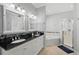 Bathroom featuring double sinks, modern fixtures, dark countertops, and a glass enclosed walk-in shower at 3421 Capland Ave, Clermont, FL 34711