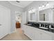 Bathroom featuring double sinks, modern fixtures, dark countertops, and decorative mirrors at 3421 Capland Ave, Clermont, FL 34711
