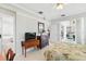 Bright bedroom with a floral bedspread, sliding glass doors and access to ensuite bath with separate tub at 3421 Capland Ave, Clermont, FL 34711